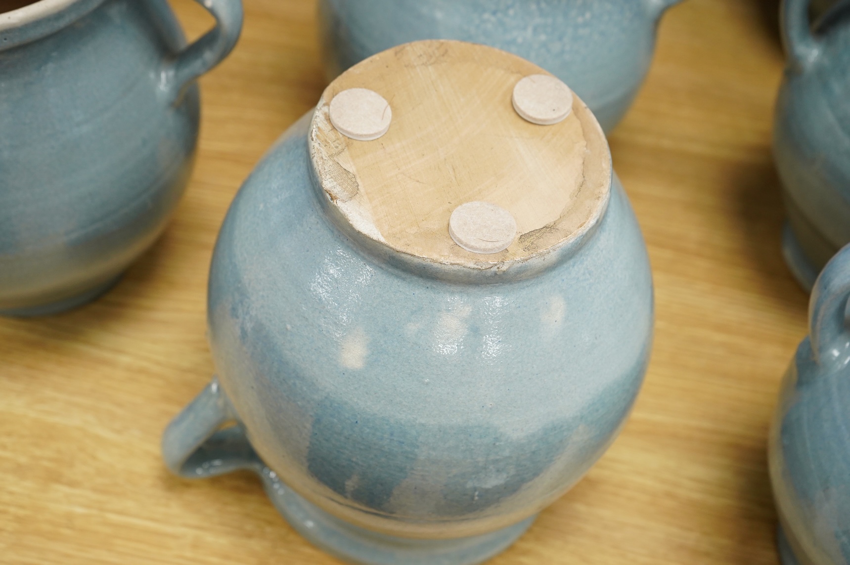 Seven early 20th century Continental blue glazed terracotta twin handled jars, 26cm high